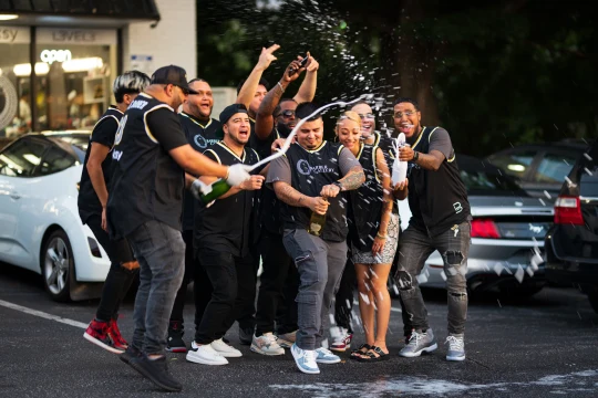The Barber Gallery team celebrating outside the barbershop.