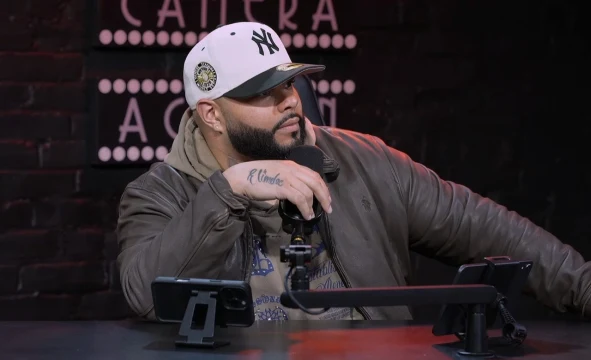 Tulpi wearing a white cap and holding a microphone during the MQB interview.