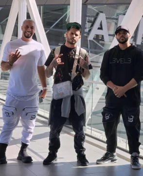 Three men posing at Miami airport during a layover.