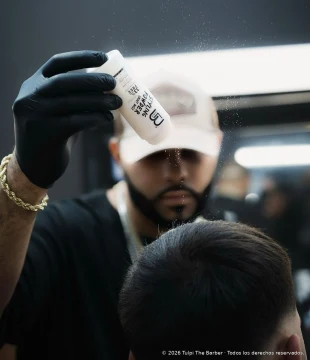 Applying a product to hair during a barbering session.