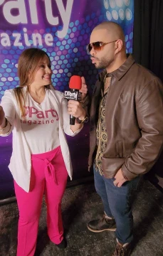 A reporter interviewing a barber with a D’Party Magazine microphone.