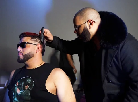 Tulpi touches up the side design of a model’s haircut during Glamour Fashion Week.
